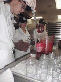 JARRING: Justin Ostensen pours the mixture into jars while Sarah Griffiths and Emma-Lea Craig attach lids.